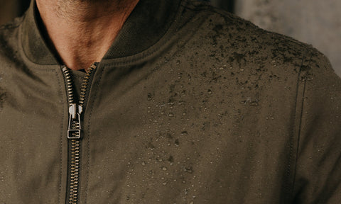 fit model showing off the wax detail on The Bomber Jacket in Fatigue Olive Dry Wax