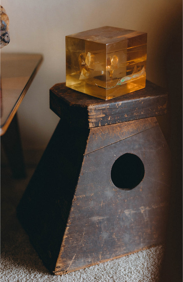 A cube atop a wooden stool