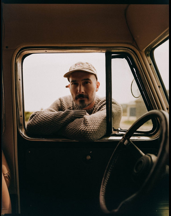 Model leaning against the window of a jeep