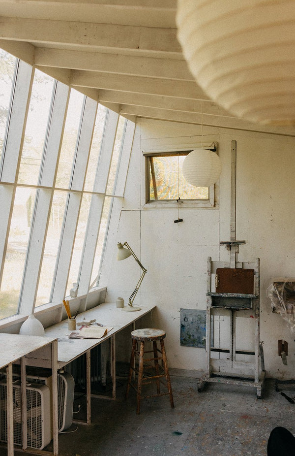 An artist's studio and workshop, with a working table and easel