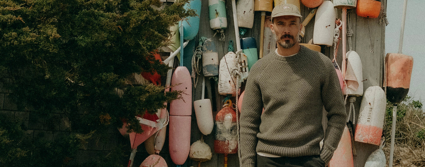 fit model posing in The Fisherman Sweater in Heather Brick Merino Wool,  by Taylor Stitch