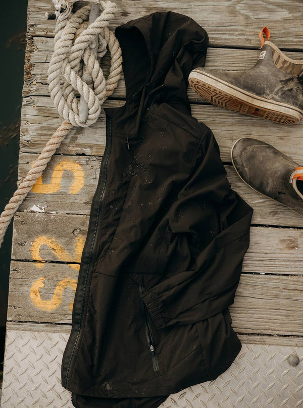 The Ridgeline Jacket in Coal, laying on the dock